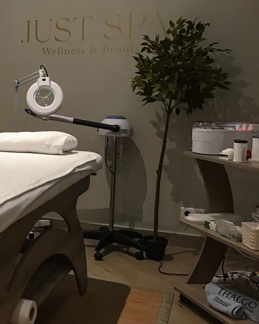 Cabine Just Spa avec lampe loupe et plante